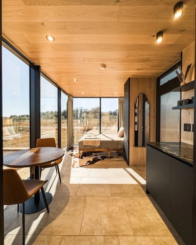 Bedroom with floor-to-ceiling windows overlooking Hill Country landscape