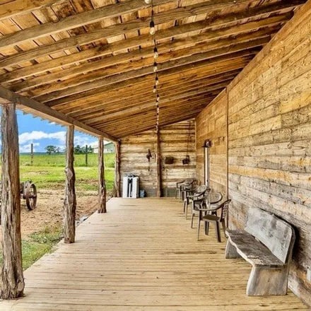 Rustic wood-beam covered porch with farm views