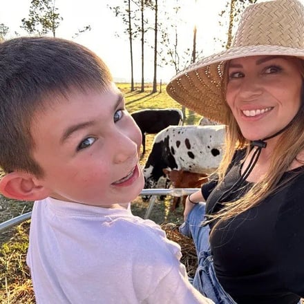 Mom and son with longhorns at golden hour at The Sanctuary